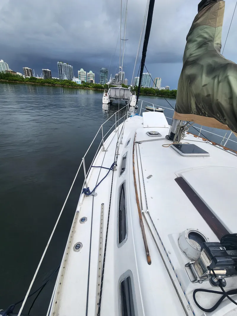 Slide: The Image of 1987 Catalina 36 sailboat on calm water with city skyline in background. - 3