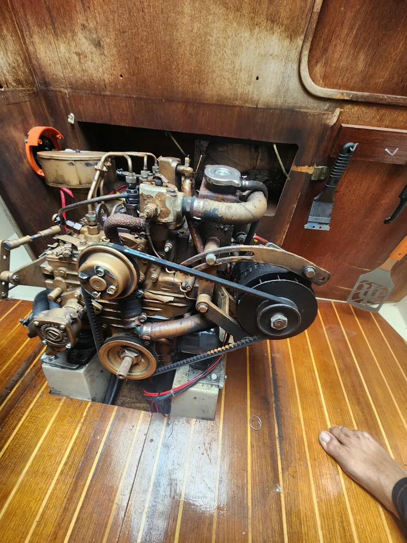 Slide: The Image of 1987 Catalina 36 engine compartment with visible mechanical components and wooden flooring. - 36