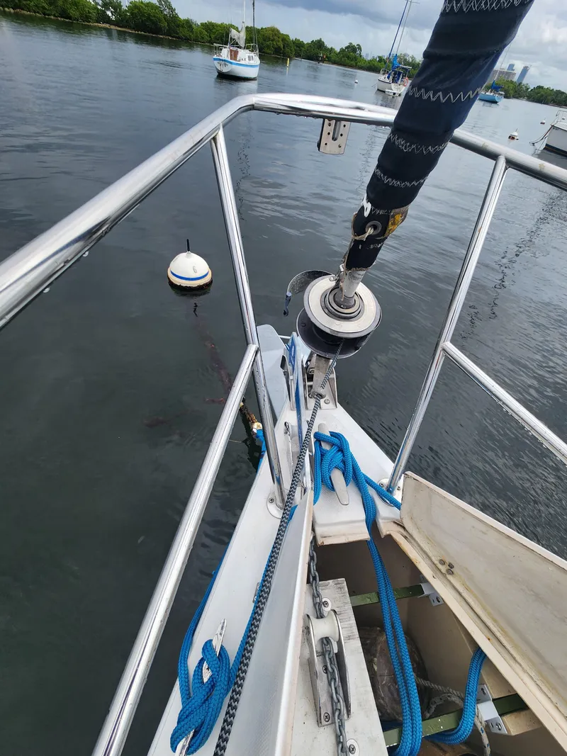Slide: The Image of Bow of 1987 Catalina 36 sailboat with mooring buoy in calm water. - 9