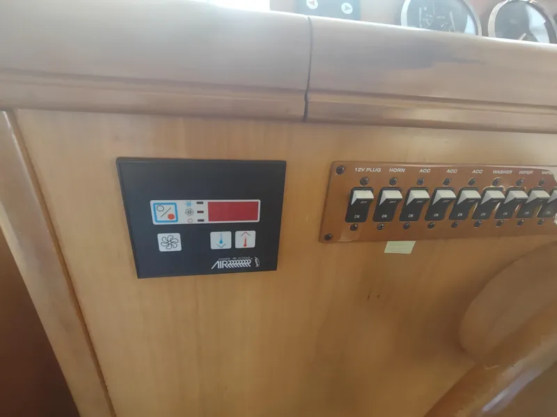 Slide: The Image of Control panel of a 2004 Mainship 400 Trawler with switches and display. - 16