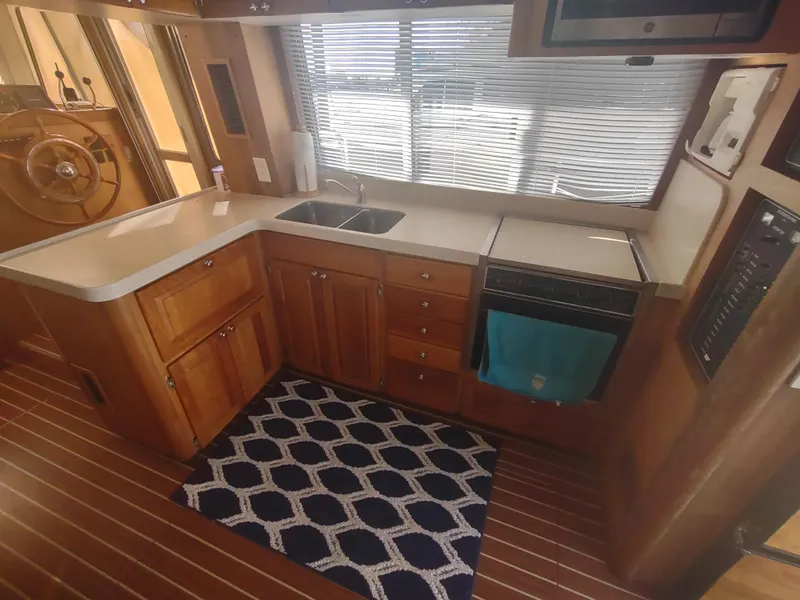 Slide: The Image of 2004 Mainship 400 Trawler kitchen with wooden cabinetry and modern appliances. - 18