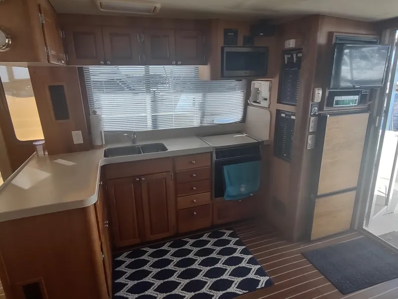 Slide: The Image of Interior of 2004 Mainship 400 Trawler kitchen with wood cabinets and modern appliances. - 19