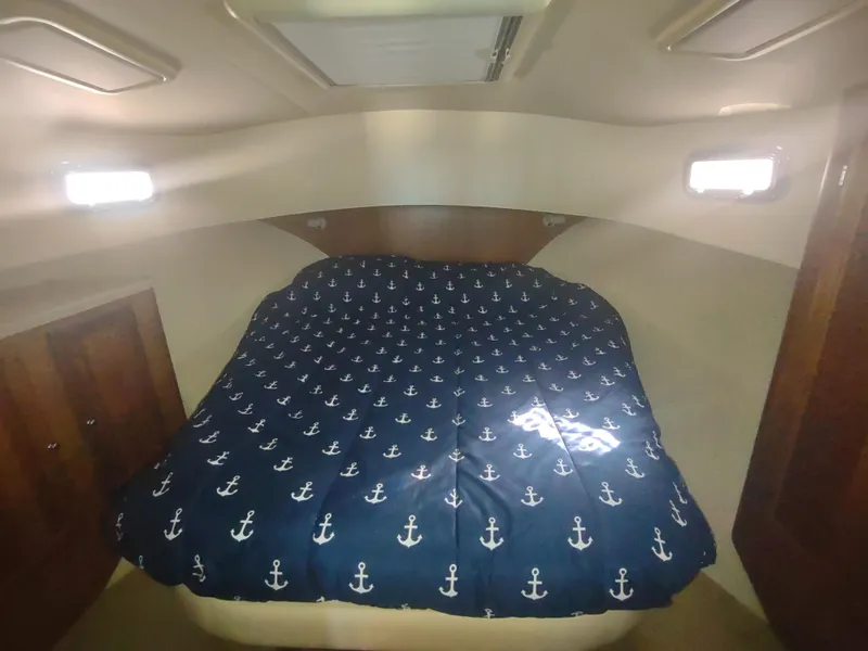 Slide: The Image of Cozy cabin interior of 2004 Mainship 400 Trawler with nautical-themed bedding. - 25