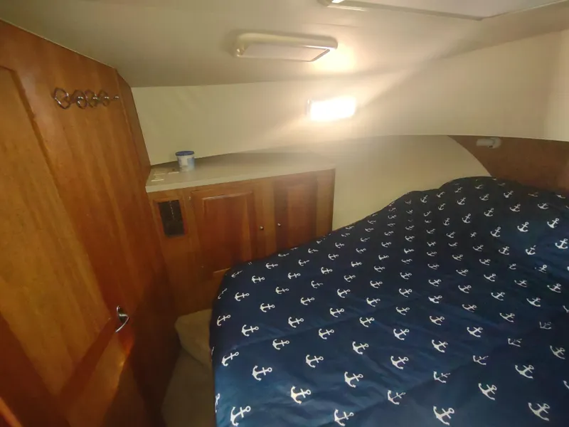 Slide: The Image of Cozy cabin interior of 2004 Mainship 400 Trawler with anchor-patterned bedding. - 27
