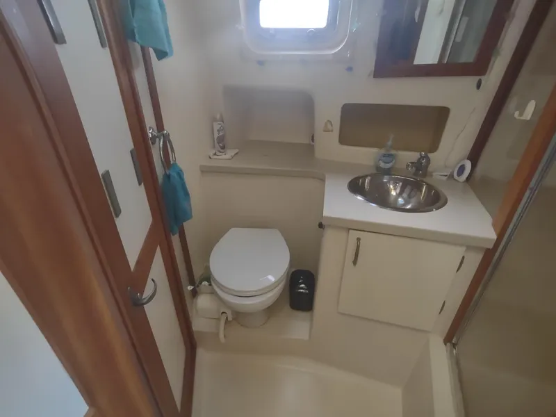 Slide: The Image of 2004 Mainship 400 Trawler bathroom with sink, toilet, and storage cabinets. - 29
