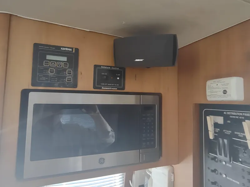 Slide: The Image of 2004 Mainship 400 Trawler interior with microwave, control panels, and speaker. - 34