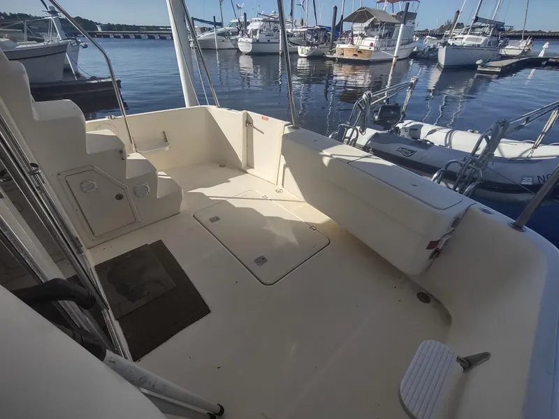 Slide: The Image of 2004 Mainship 400 Trawler deck view at marina, showcasing spacious seating and storage. - 40