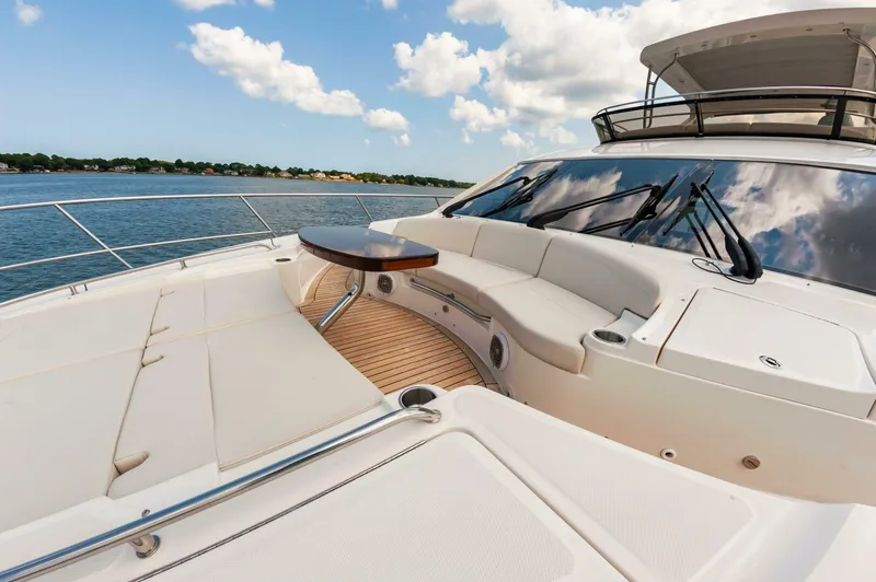 Slide: The Image of Luxurious 2015 Sea Ray L659 Fly yacht deck with seating and table, under a clear sky. - 12