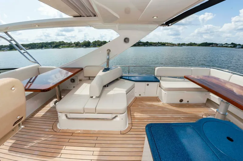 Slide: The Image of Luxurious 2015 Sea Ray L659 Fly yacht interior with elegant seating and wooden tables. - 19
