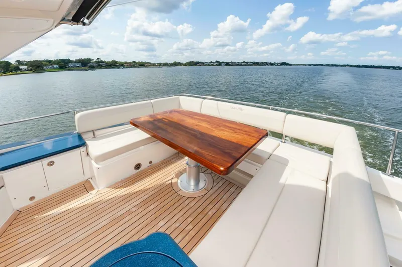 Slide: The Image of Luxurious 2015 Sea Ray L659 Fly yacht deck with elegant seating and wooden table. - 21