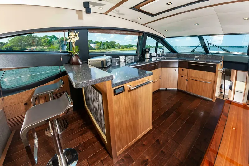 Slide: The Image of Luxurious interior of 2015 Sea Ray L659 Fly yacht with modern kitchen and bar stools. - 35