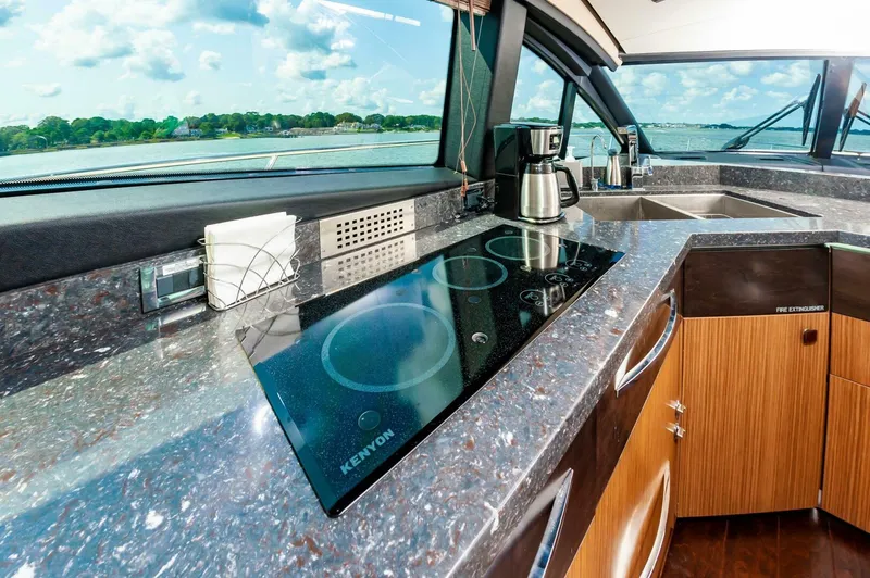 Slide: The Image of Luxurious 2015 Sea Ray L659 Fly yacht kitchen with modern appliances and scenic water view. - 38