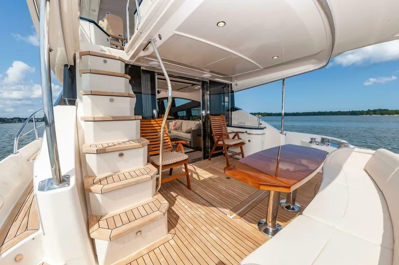 Slide: The Image of Luxurious 2015 Sea Ray L659 Fly yacht deck with wooden seating and table. - 8