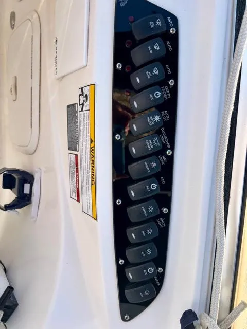 Slide: The Image of Control panel of a 2009 Meridian 391 Sedan boat with labeled switches and warning label. - 25