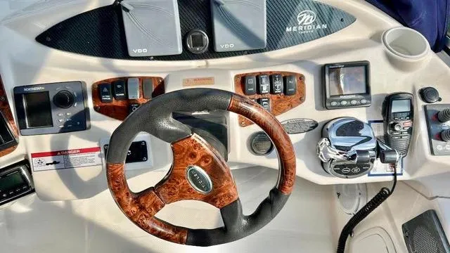 Slide: The Image of 2009 Meridian 391 Sedan helm with wood-accented steering wheel and navigation controls. - 27