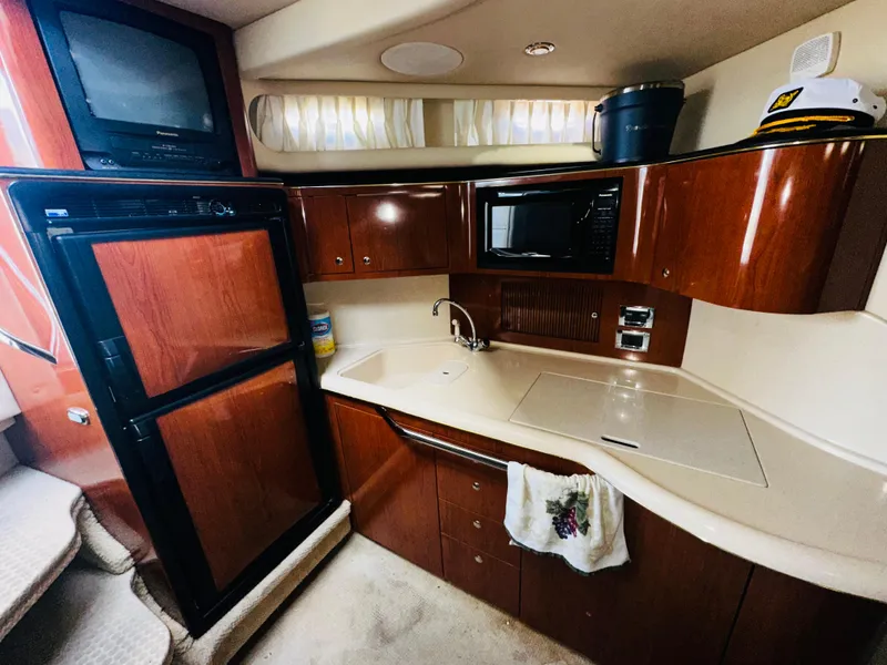 Slide: The Image of 2002 Sea Ray 380 Sundancer yacht kitchen with wood cabinets and modern appliances. - 10