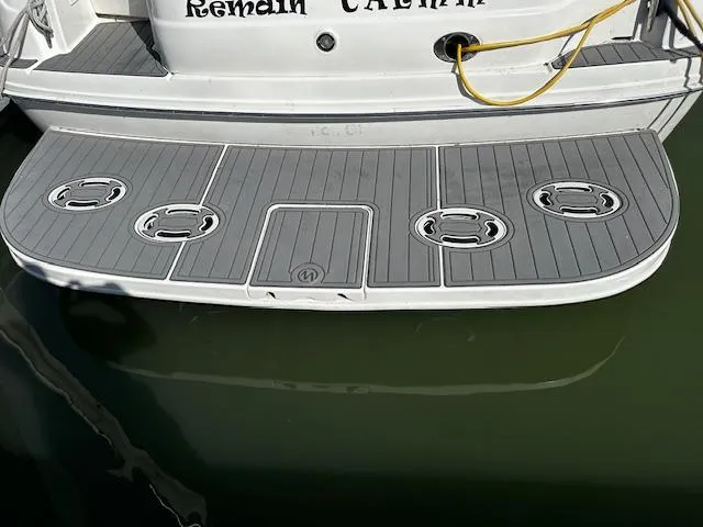 Slide: The Image of 2002 Sea Ray 380 Sundancer swim platform with gray decking and mooring cleats. - 2