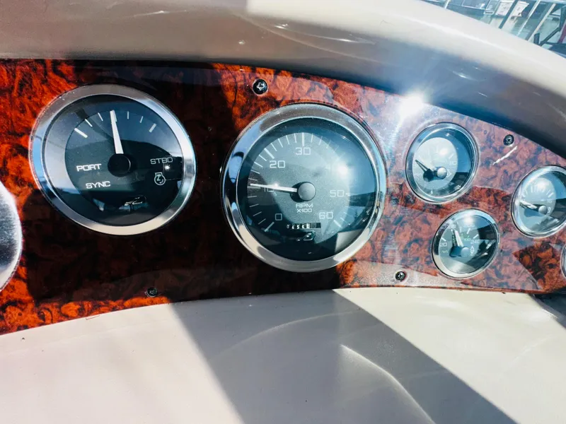 Slide: The Image of Dashboard of a 2002 Sea Ray 380 Sundancer boat with gauges and wood paneling. - 8