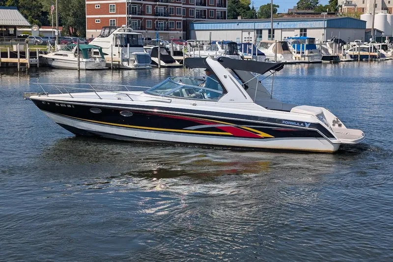 The Image of 2006 Formula 330 Sun Sport boat docked in a marina with other vessels. - 0