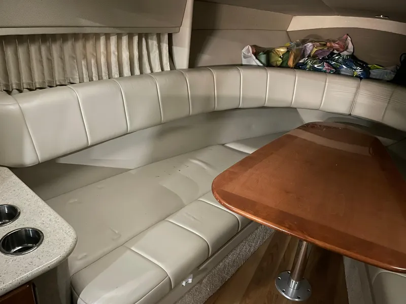 Slide: The Image of 2006 Formula 330 Sun Sport cabin with beige seating and wooden table. - 21