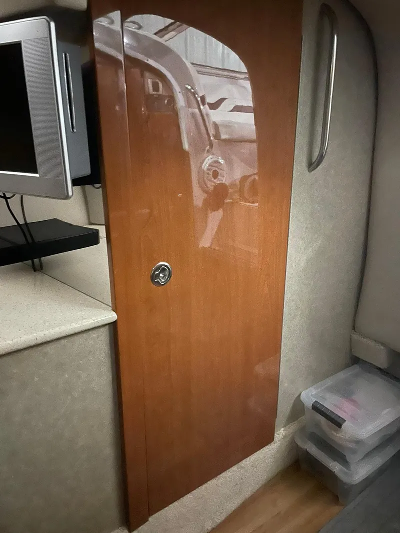 Slide: The Image of Interior of 2006 Formula 330 Sun Sport boat with wooden cabinet and TV. - 26