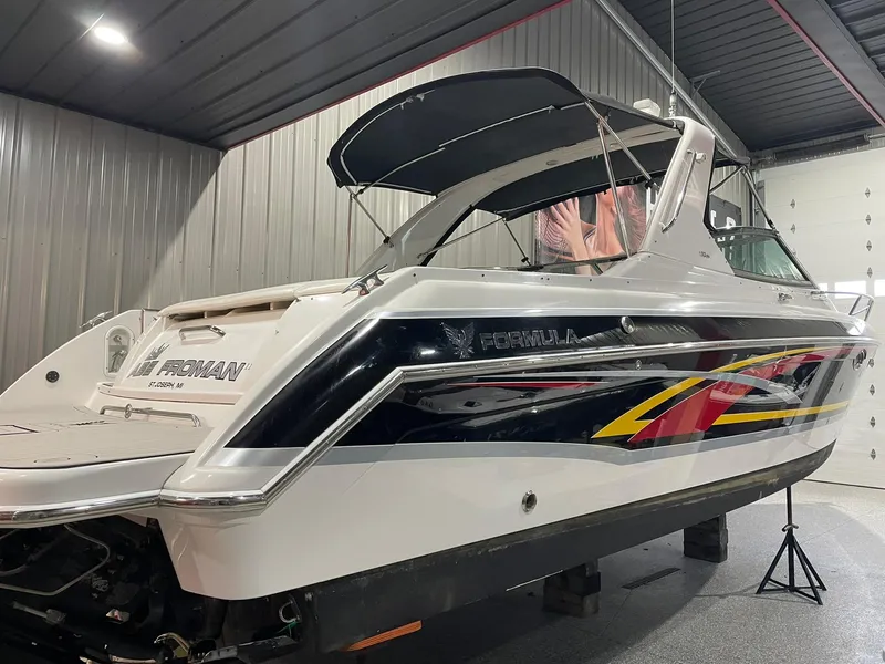 Slide: The Image of 2006 Formula 330 Sun Sport boat in a garage, featuring sleek design and vibrant graphics. - 6