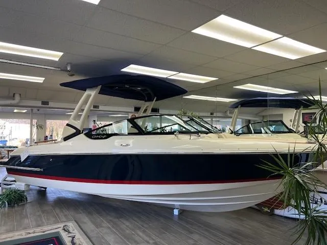 The Image of 2025 Chris-Craft Sportster 25 boat displayed indoors, sleek design with blue and white exterior. - 0
