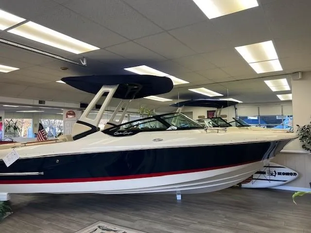 Slide: The Image of 2025 Chris-Craft Sportster 25 boat displayed in showroom with modern design. - 1