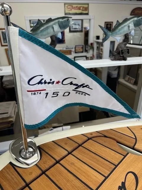 Slide: The Image of Chris-Craft Sportster 25 flag celebrating 150th anniversary, displayed indoors. - 17