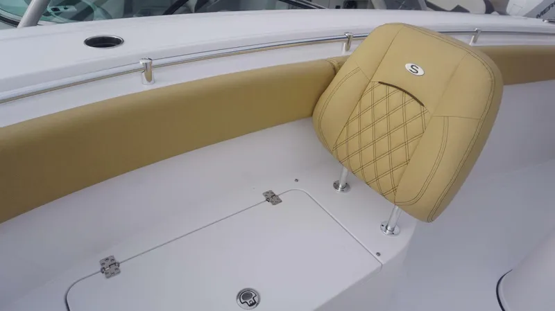 Slide: The Image of 2025 Sportsman 282 Open boat interior with tan cushioned seating and storage compartment. - 11