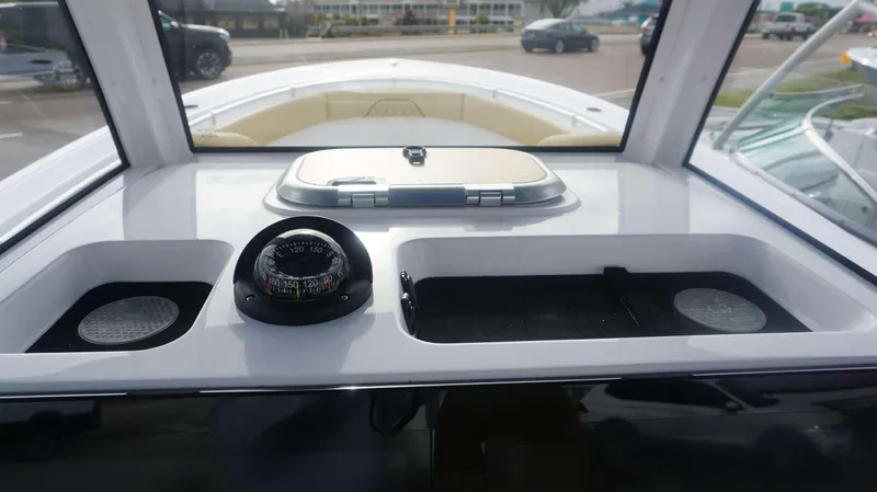 Slide: The Image of 2025 Sportsman 282 Open boat dashboard with compass and storage compartments. - 25