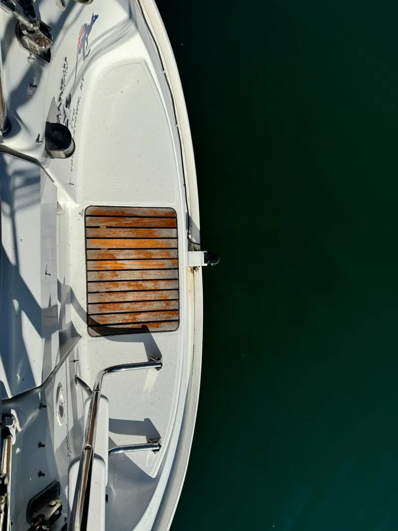 Slide: The Image of Jeanneau Sun Odyssey 40 sailboat deck, 2001 model, with wooden platform over calm water. - 18