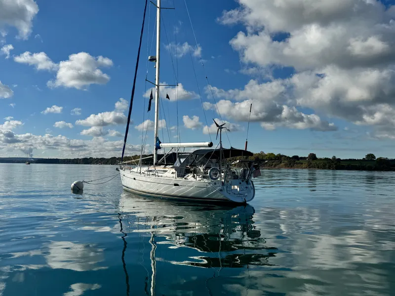 Slide: The Image of Jeanneau Sun Odyssey 40 sailboat on calm water under a partly cloudy sky. - 2