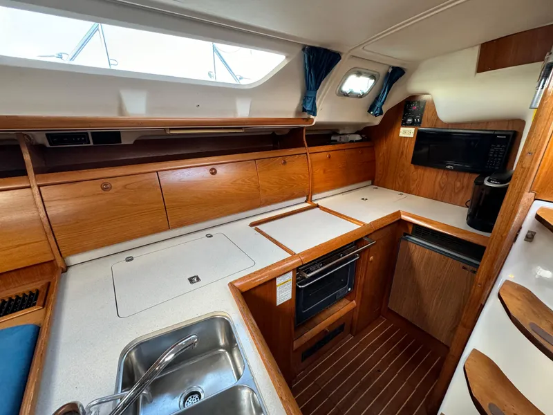 Slide: The Image of Interior of 2001 Jeanneau Sun Odyssey 40 yacht kitchen with wood cabinetry and modern appliances. - 22