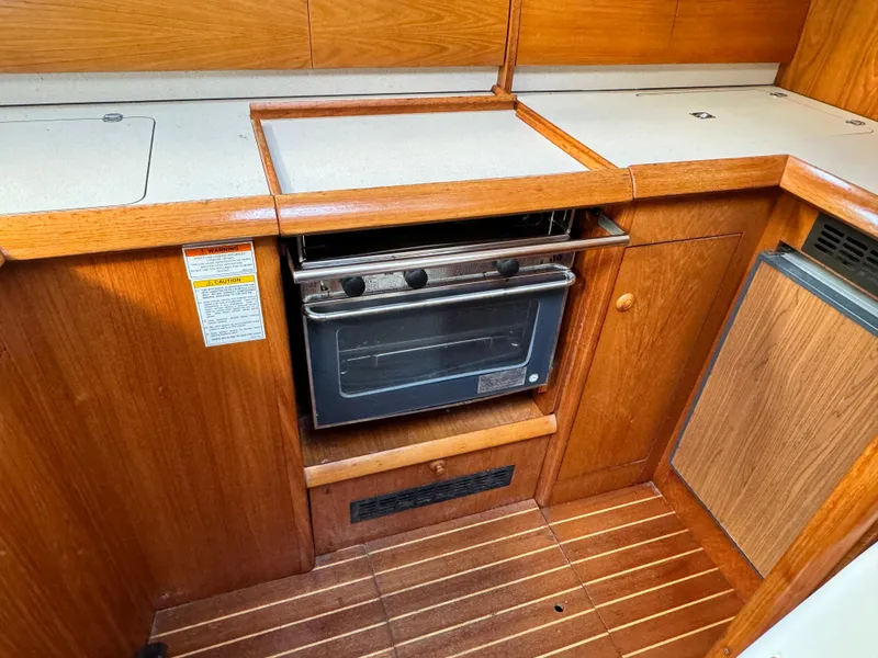 Slide: The Image of 2001 Jeanneau Sun Odyssey 40 yacht kitchen with wooden cabinetry and built-in oven. - 28