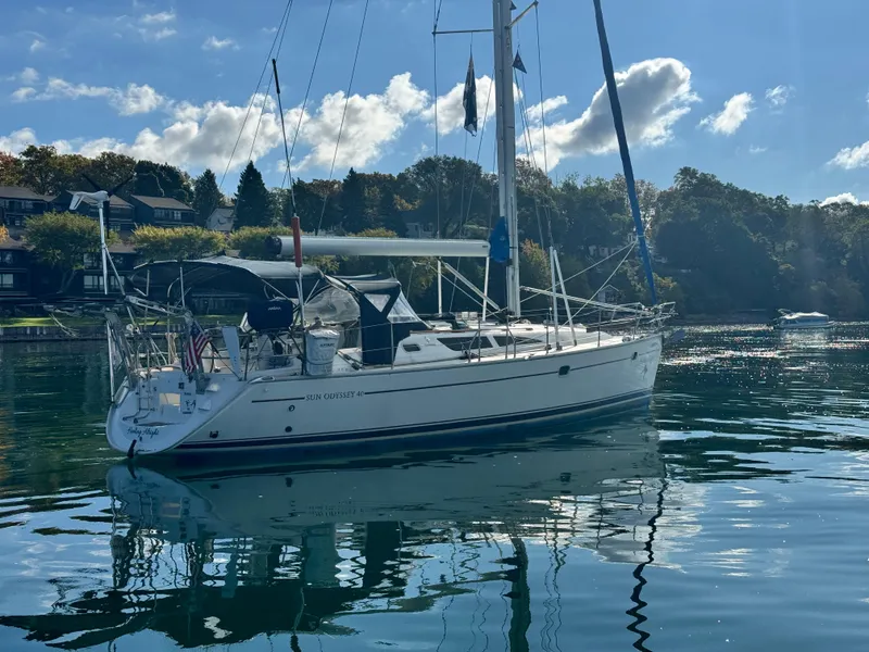 Slide: The Image of 2001 Jeanneau Sun Odyssey 40 sailboat on calm water, with scenic background. - 3