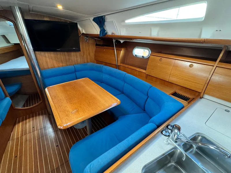 Slide: The Image of Interior of 2001 Jeanneau Sun Odyssey 40 sailboat with blue seating and wooden table. - 30