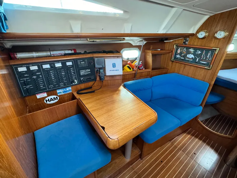 Slide: The Image of Interior of 2001 Jeanneau Sun Odyssey 40 sailboat with blue seating and wooden table. - 32
