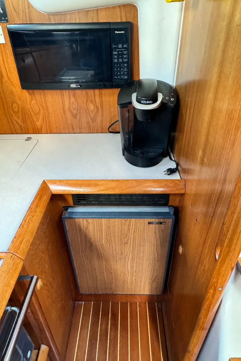 Slide: The Image of Galley of 2001 Jeanneau Sun Odyssey 40 with microwave, coffee maker, and compact fridge. - 34