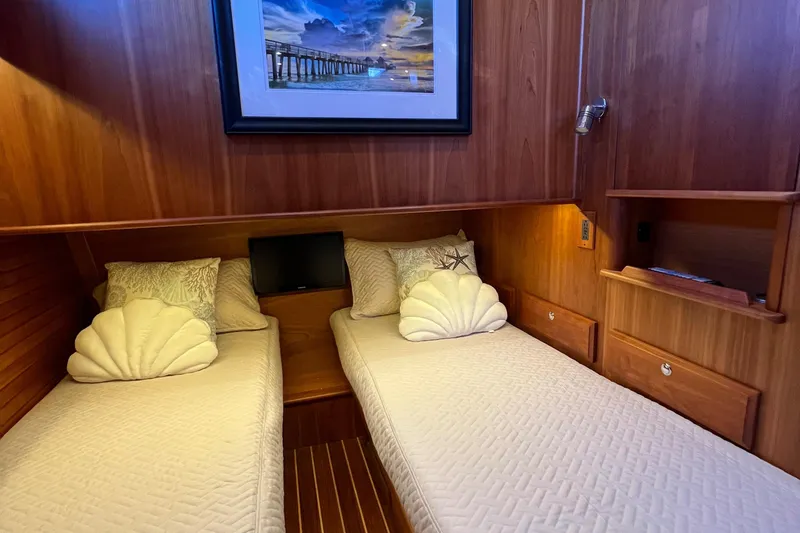 Slide: The Image of Twin beds in 2018 Sabre 45 Salon Express cabin with wood paneling and decorative pillows. - 24