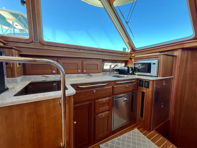 Slide: The Image of 2018 Sabre 45 Salon Express yacht kitchen with wood cabinetry and modern appliances. - 27