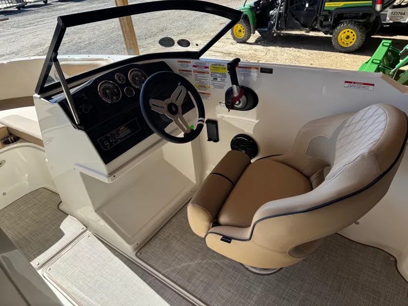 Slide: The Image of 2025 Bayliner VR4 Bowrider I/O cockpit with steering wheel and beige captain's seat. - 11