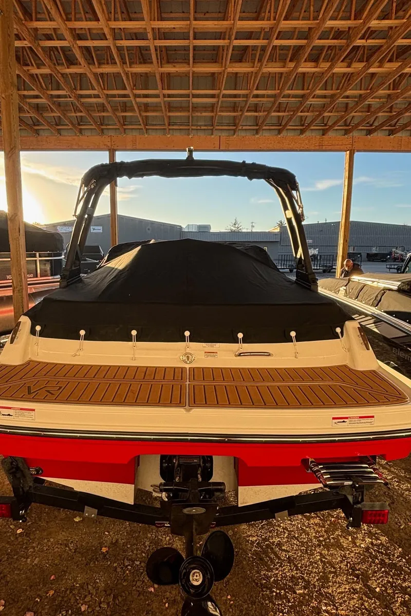 Slide: The Image of 2025 Bayliner VR4 Bowrider I/O under a wooden shelter at sunset. - 23