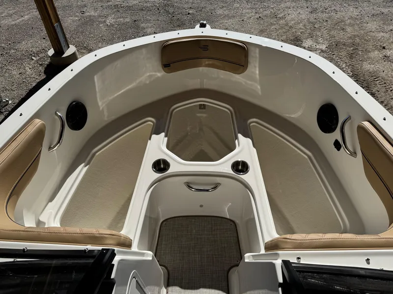 Slide: The Image of 2025 Bayliner VR4 Bowrider I/O interior with beige seating and cup holders. - 9