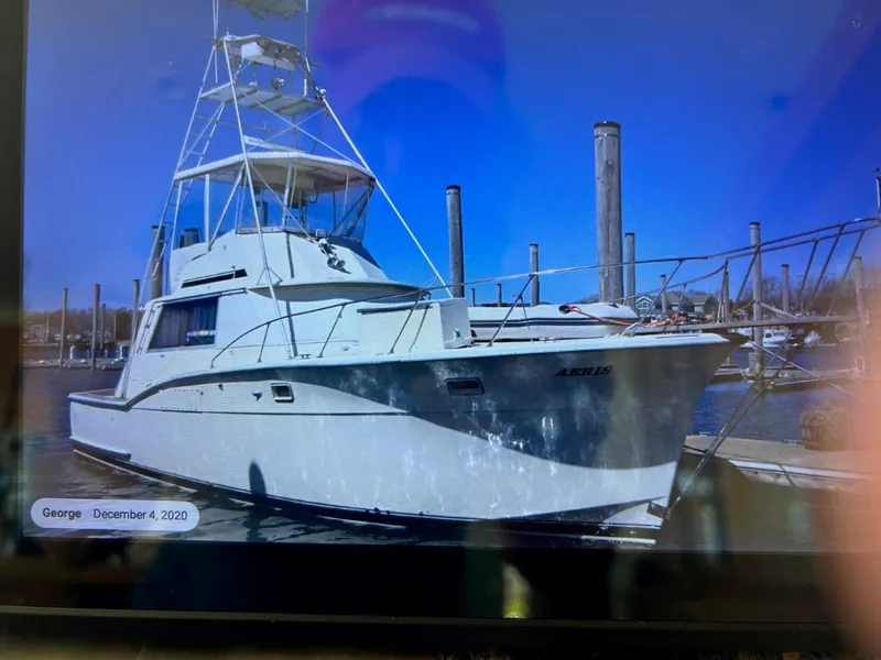 Slide: The Image of 1968 Hatteras 45 Convertible yacht docked at marina under clear blue sky. - 6