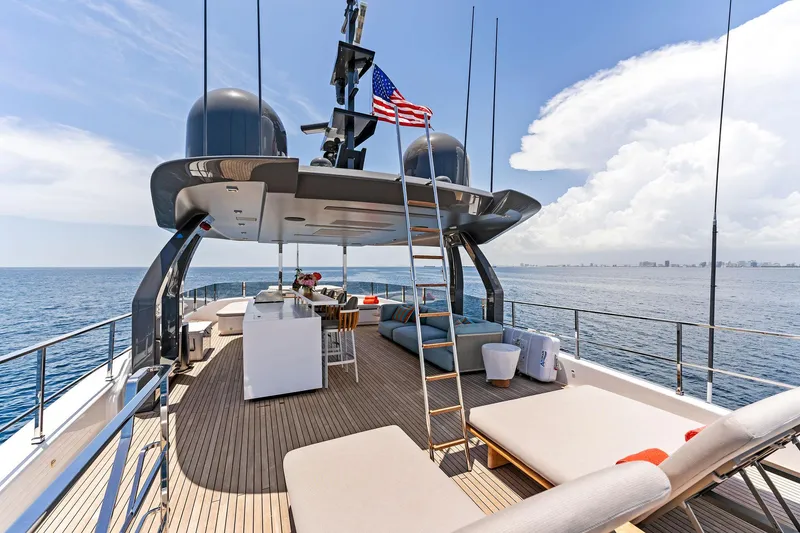 Slide: The Image of Luxurious 2024 Custom Line Navetta 33 yacht deck with seating, ocean view, and American flag. - 17