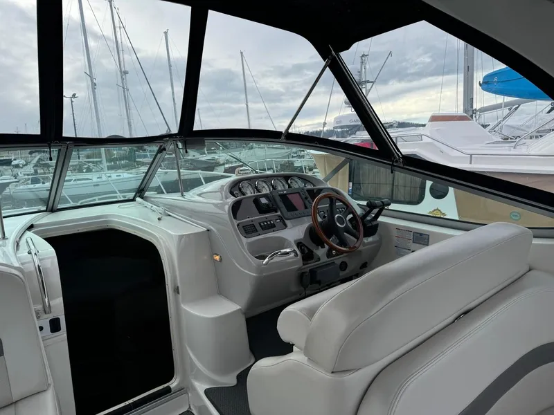 Slide: The Image of 2005 Chaparral Signature 310 boat interior with helm, steering wheel, and marina view. - 13