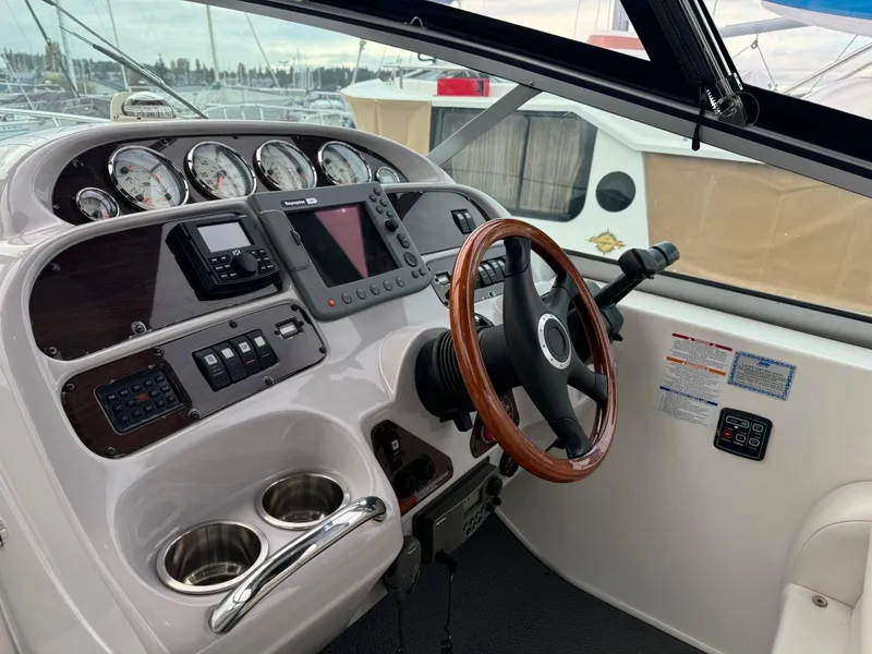 Slide: The Image of 2005 Chaparral Signature 310 helm with wood steering wheel and modern navigation instruments. - 14
