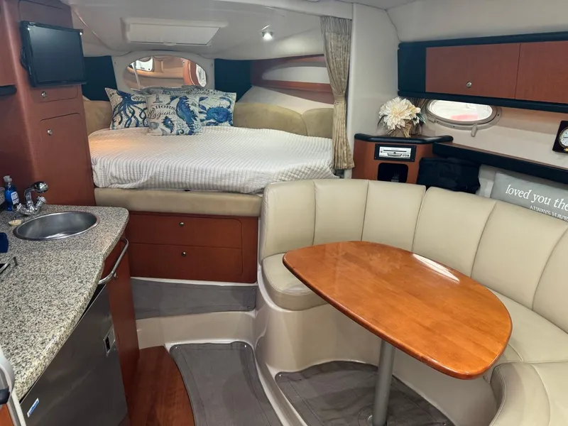 Slide: The Image of 2005 Chaparral Signature 310 interior with cozy seating, kitchenette, and bed. - 23