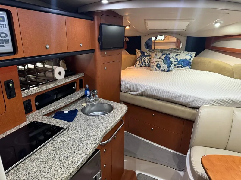 Slide: The Image of 2005 Chaparral Signature 310 interior with kitchenette, bed, and seating area. - 24